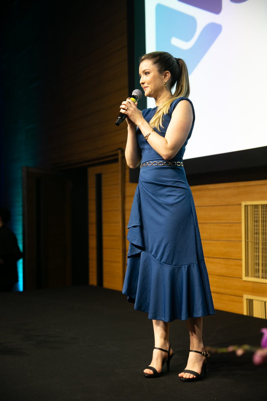 Apresentadora ao microfone no palco
